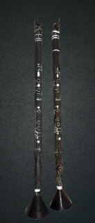 Two black and silver clarinets in a greyish-black background.