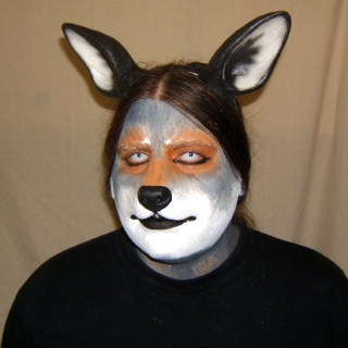 A man wearing a foam latex wolf nose prosthetic with makeup and ears