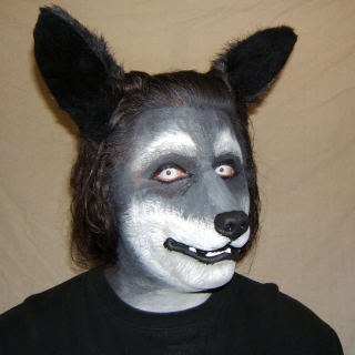 A man wearing a foam latex wolf muzzle prosthetic with makeup and ears