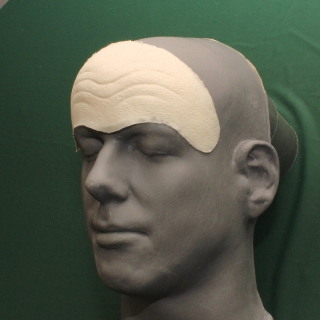 A shrek forehead prosthetic on a platic human face cast.