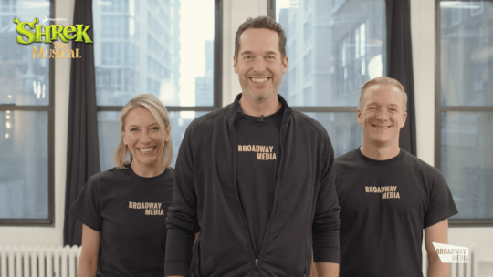 Three people in black shirts that say 