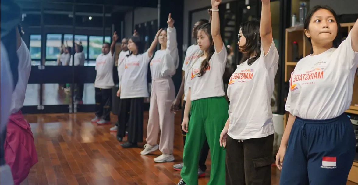 Kids performing a Camp Broadway Edition show, standing in a line and pointing upward