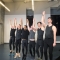 A row of six male dancers raising their hands